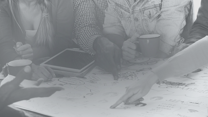 Black-and-white image of a team collaborating over sketches and notes at a table