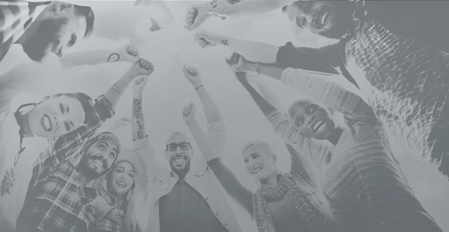 Group of diverse professionals raising hands in a circle, smiling