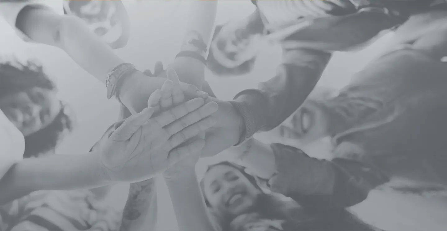 a diverse team stacking hands in a circle, representing teamwork for mission-driven marketing