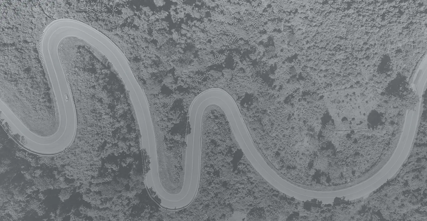 Black and white abstract image of a winding path across textured terrain, representing journey mapping, and strategic direction